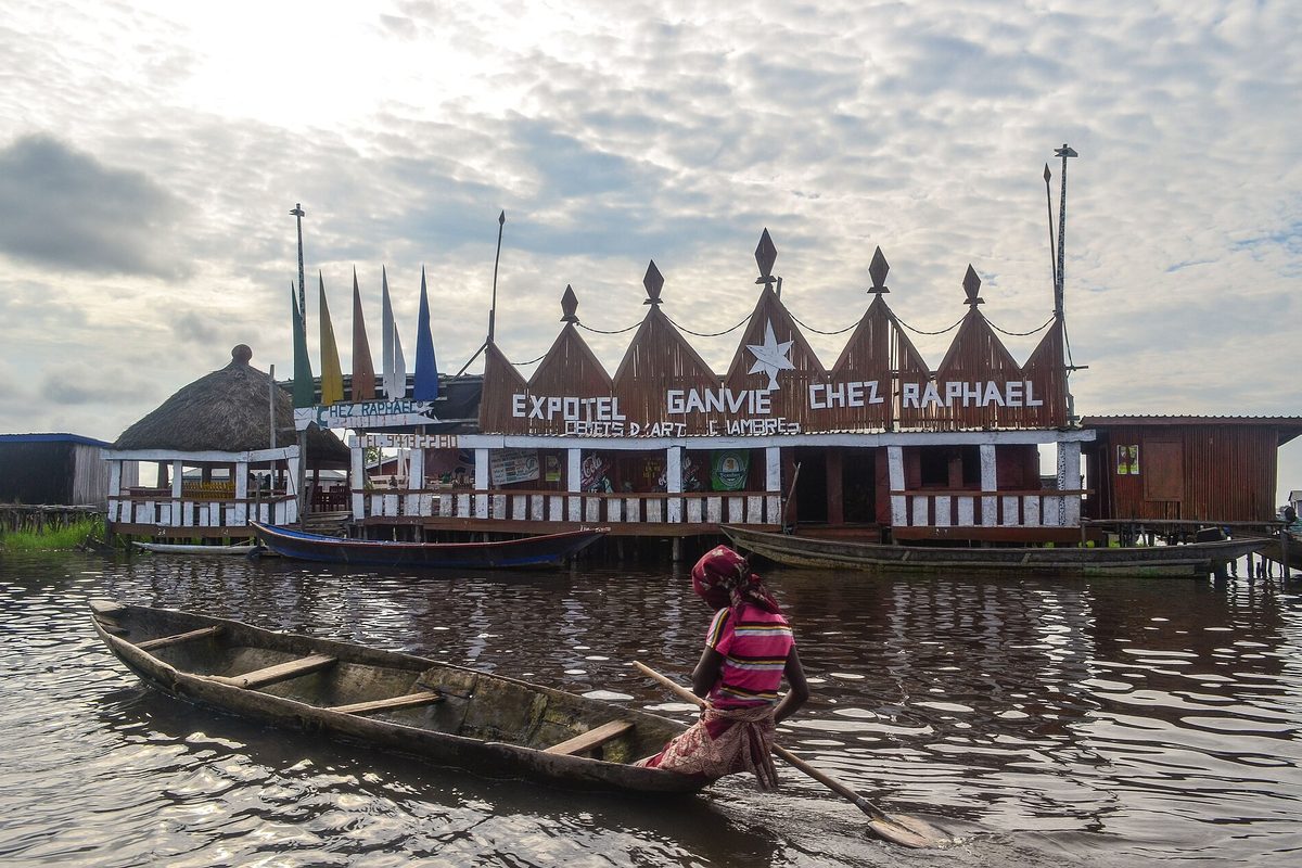 Pirogue gliding through Ganvié stilt village on Lake Nokoué